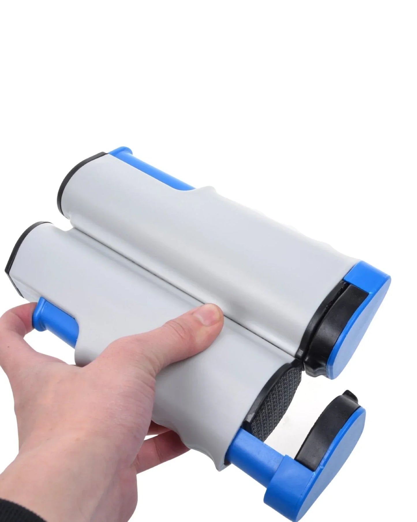 Brinquedo infantil educativo, peça cinza e azul, sendo segurada por uma mão, fundo branco.